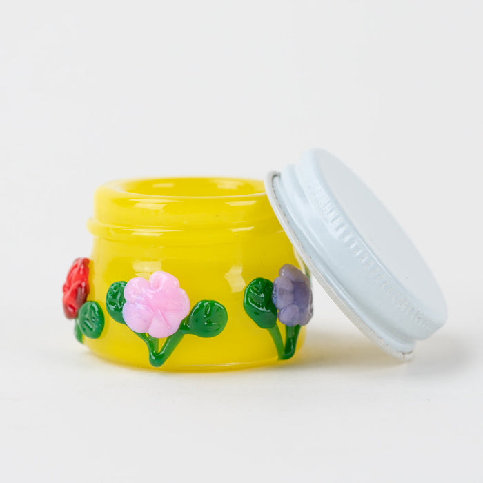 Open Empire Glassworks Sunshine Garden concentrate jar showing white lid and yellow glass interior