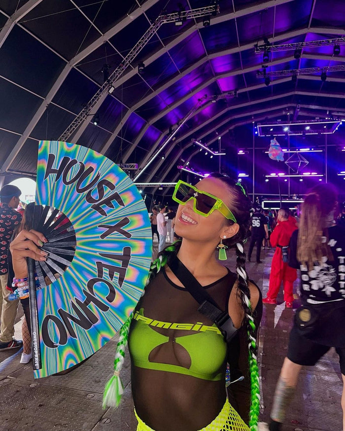 House X Techno hand fan held at festival psychedelic swirl design