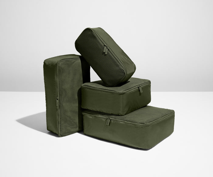 A set of four packed Insider Packing Cubes stacked on top of each other