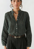A woman wearing a dark grey cotton eyelet blouse.