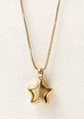 A gold necklace with a puffy star locket pendant.