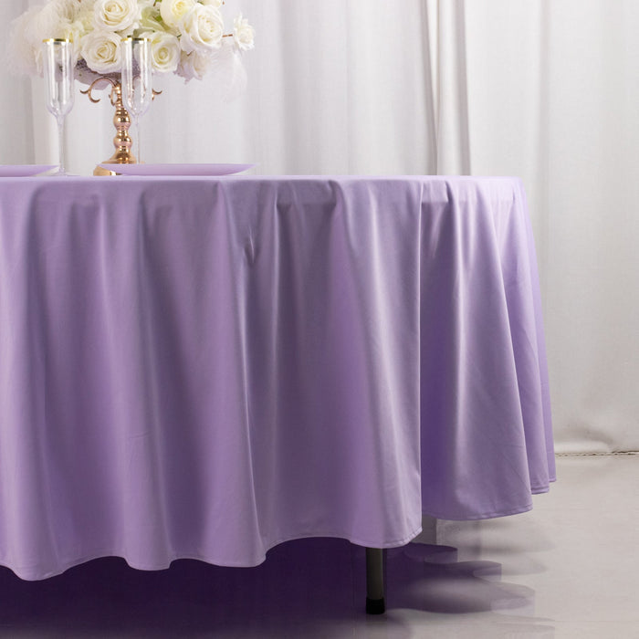 Lavender tablecloth draped elegantly over a round table with floral centerpiece.