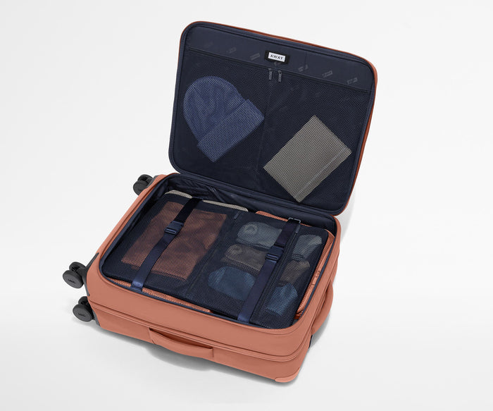 Open Softside suitcase, with travel essentials in the front flap pocket and compression pad pockets