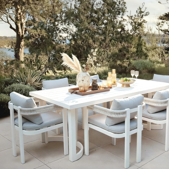 Outdoor patio dining set with table and six chairs by the water