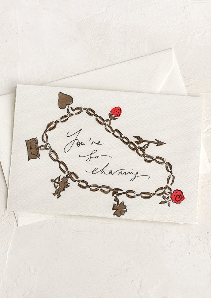 A card with hand painted illustration of a charm bracelet, text reads "You're So Charming".